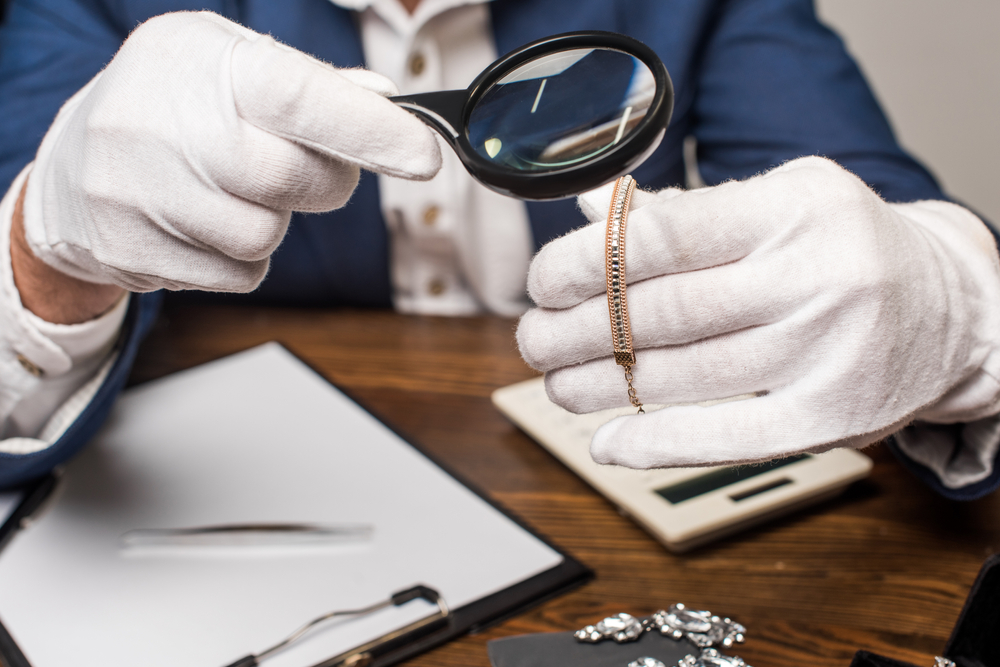Appraiser examining an estate necklace with a magnifying glass