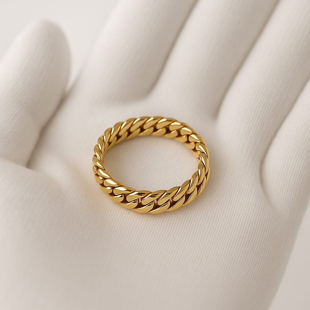 Detail of 18K Yellow Gold Cuban Link Ring held by a white-gloved hand