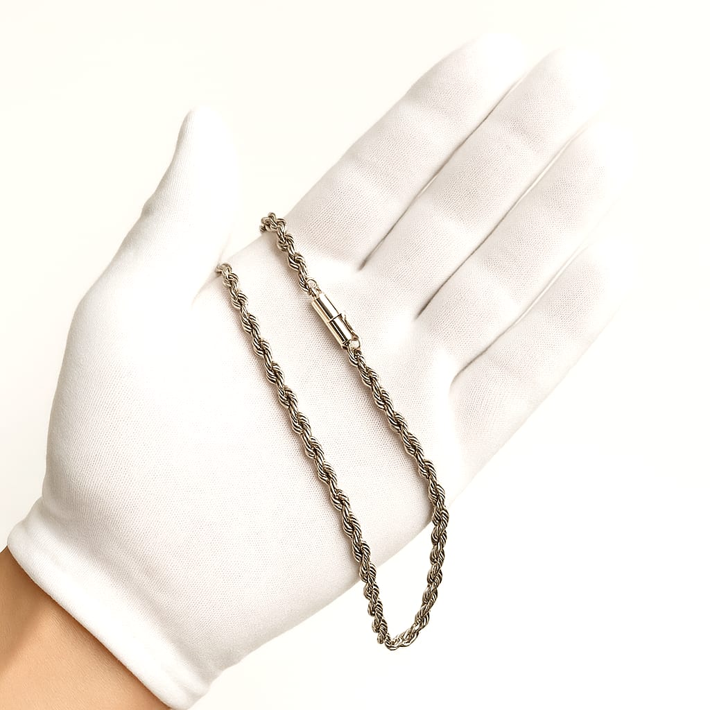 Close-up of the chain held by a white-gloved hand