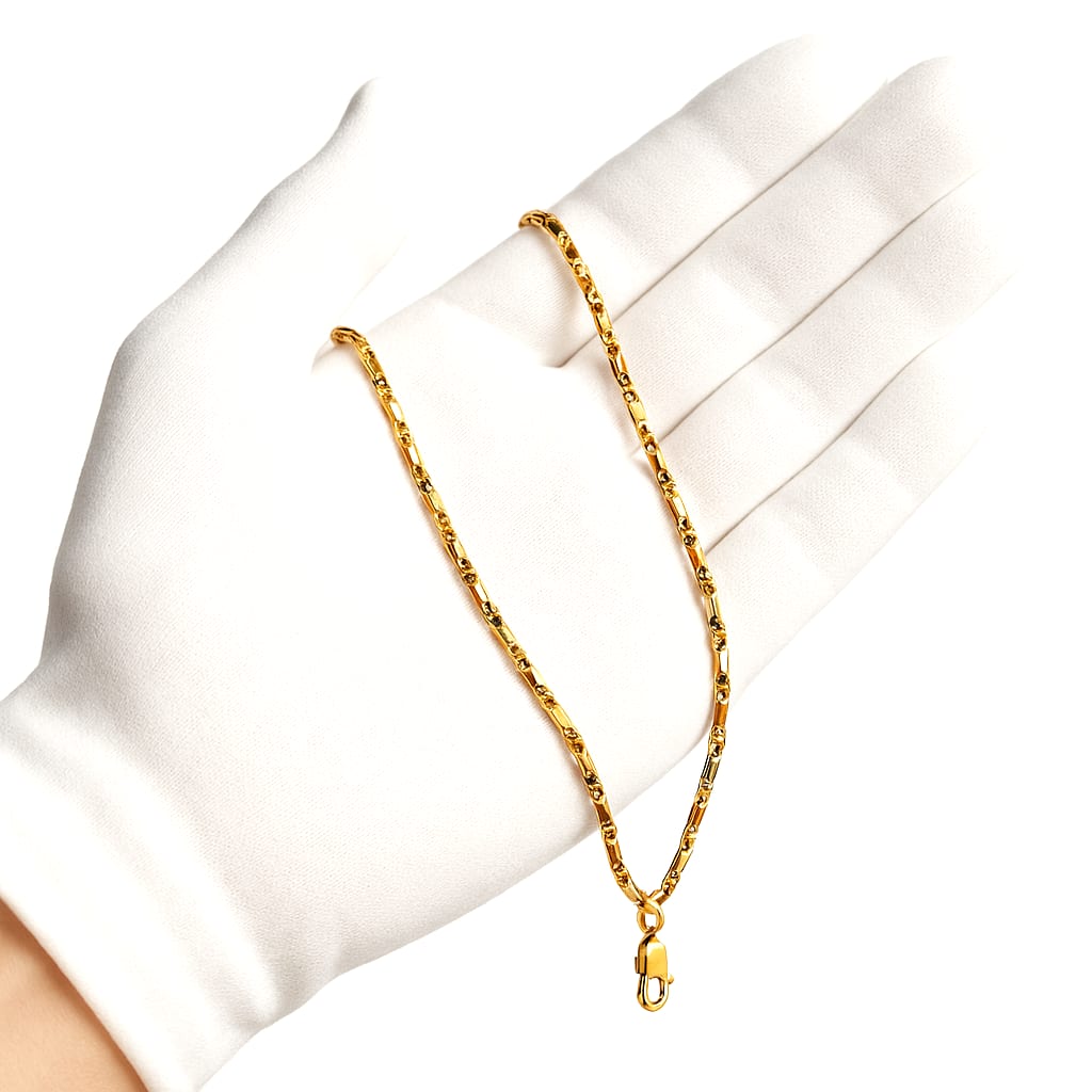 Close-up of mirrored bar-link chain held by white-gloved hand