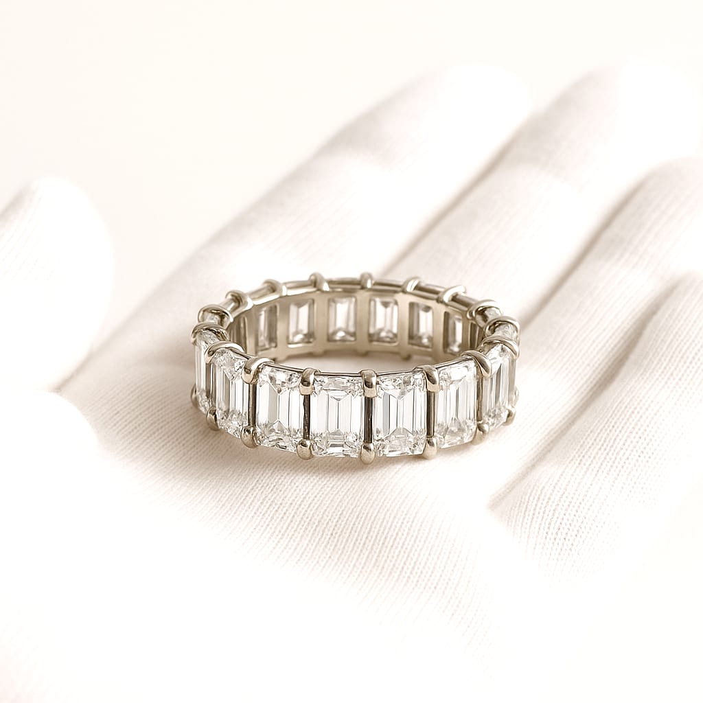 Detailed view of the diamond eternity band held by a white-gloved hand