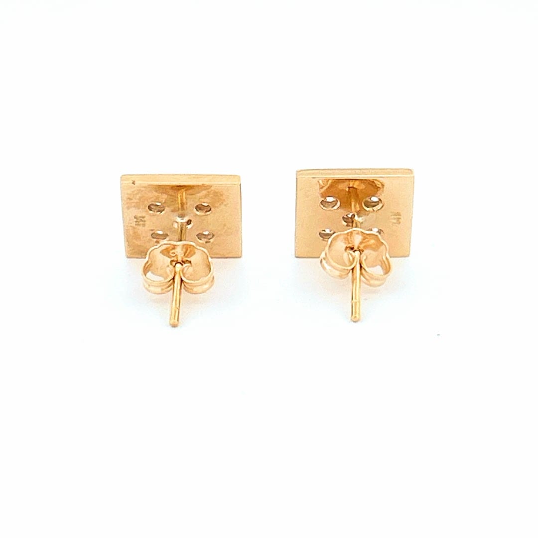 Earrings displayed on a stand showing their craftsmanship and shine.