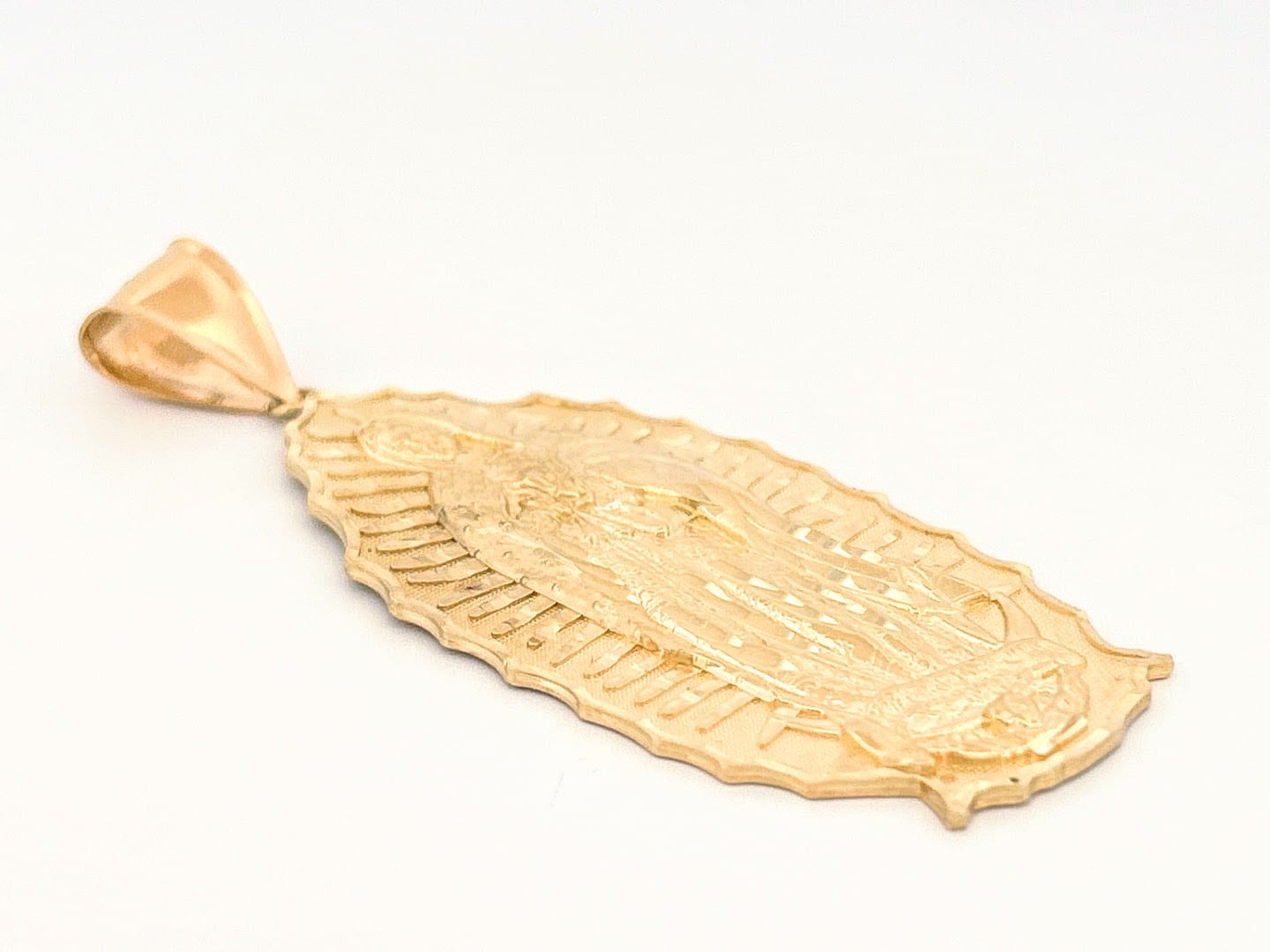 Pendant showing detailed engraving and yellow gold sheen